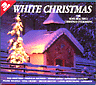 Omslag: White Christmas med foto av en snöig stuga och en gran i halvmörker