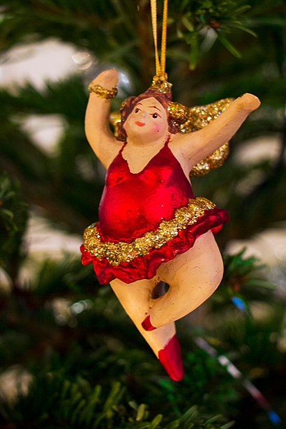 Foto av julpynt i julgranen, i form av en balettdansande kvinna i röd klänning och guldglitter